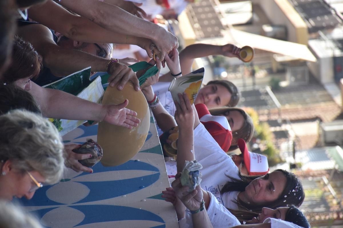 Los clavarios reparten cerámica desde su carroza.