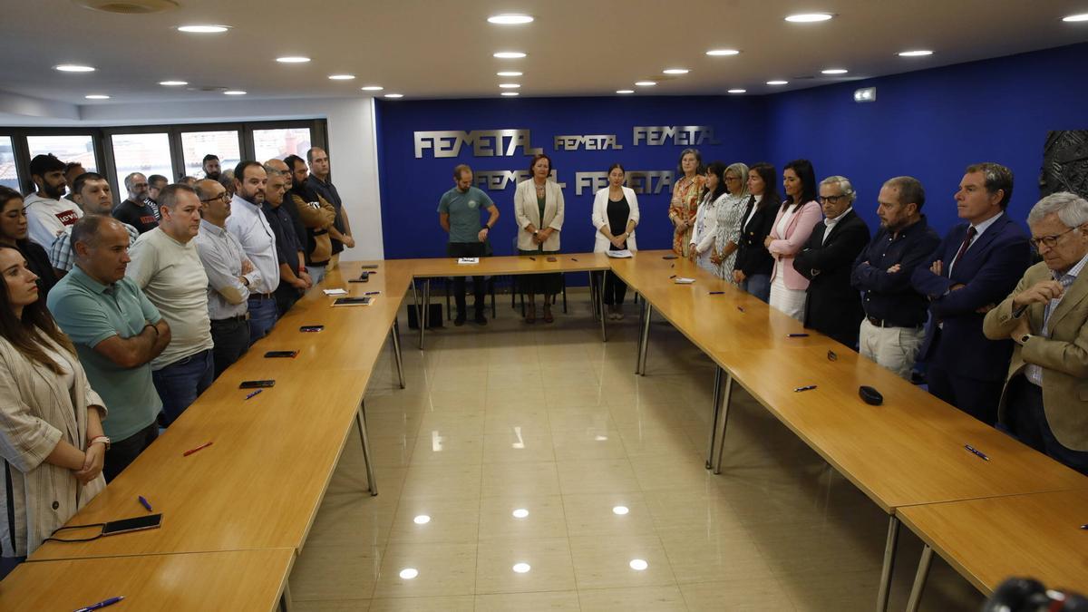 Los representantes de Femetal, a la derecha, y de UGT y CC OO, a la izquierda, durante el minuto de silencio.