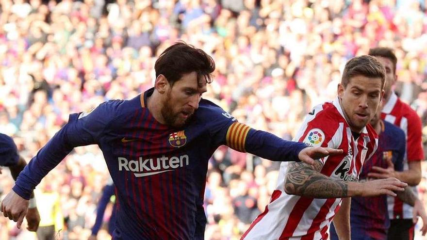 Messi conduce el balón perseguido por Íñigo Martínez.