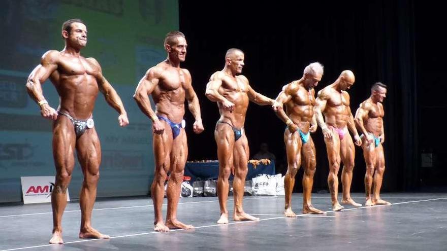 Un grupo de participantes mostrando músculo sobre el escenario, ayer, en la Pola.