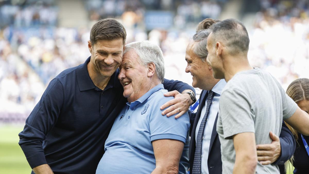 John Benjamin Toshack recibe la Insignia de Oro y Brillantes de la Real Sociedad, acompañado de los entrenadores Xabi Alonso y Sergio Francisco.