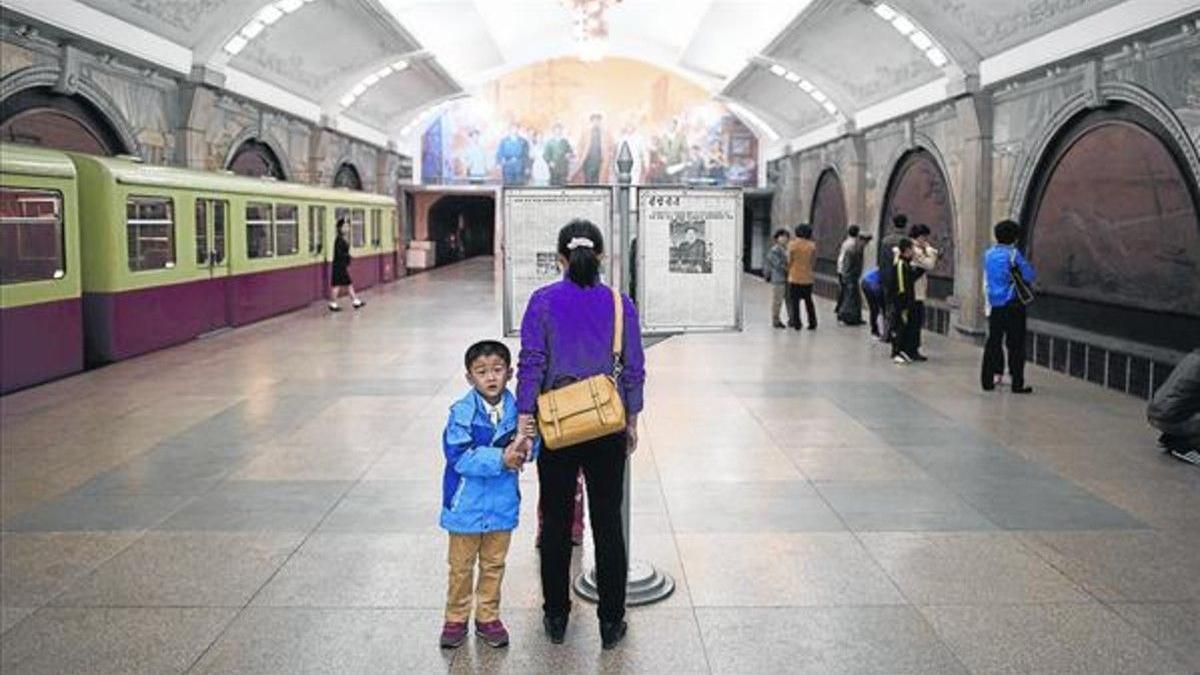 Una mujer lee el diario en una estación del metro de Pionyang.