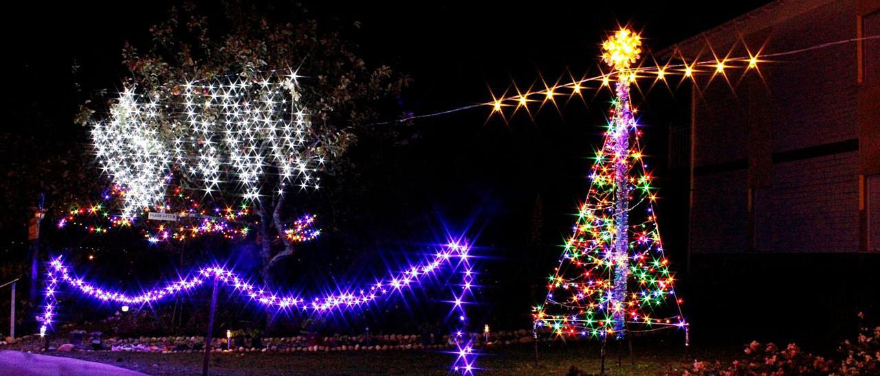 Parte de la instalación de luces de Navidad en la finca de Miguel Busto. En el círculo, el joven, durante el montaje de su instalación en La Trapa.