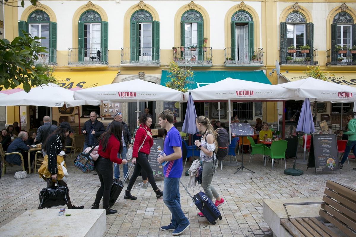 Turistas con sus maletas en el Centro de Málaga.