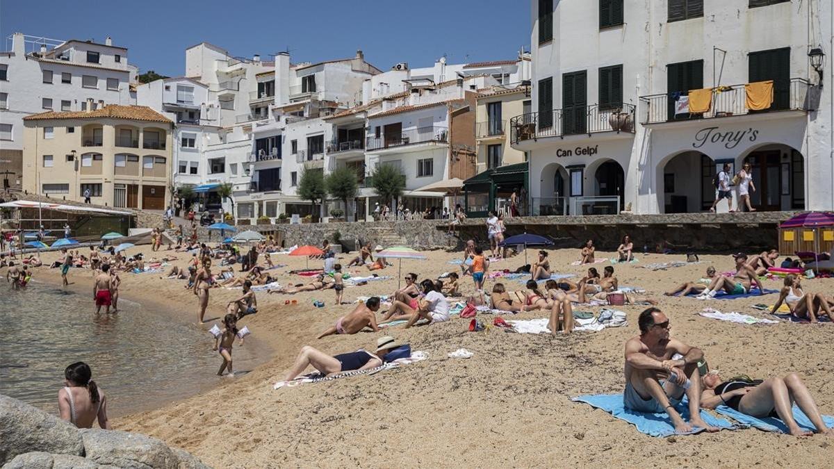 Bañistas disfrutan del primer día sin estado de alarma en la playa en la Calella de Palafruguell.