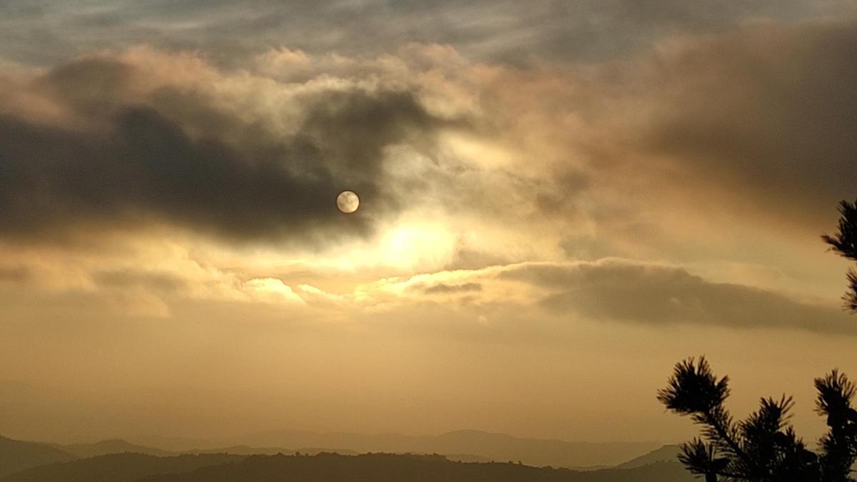 Coll de Jou, el Sol entremig de boires i núvols.