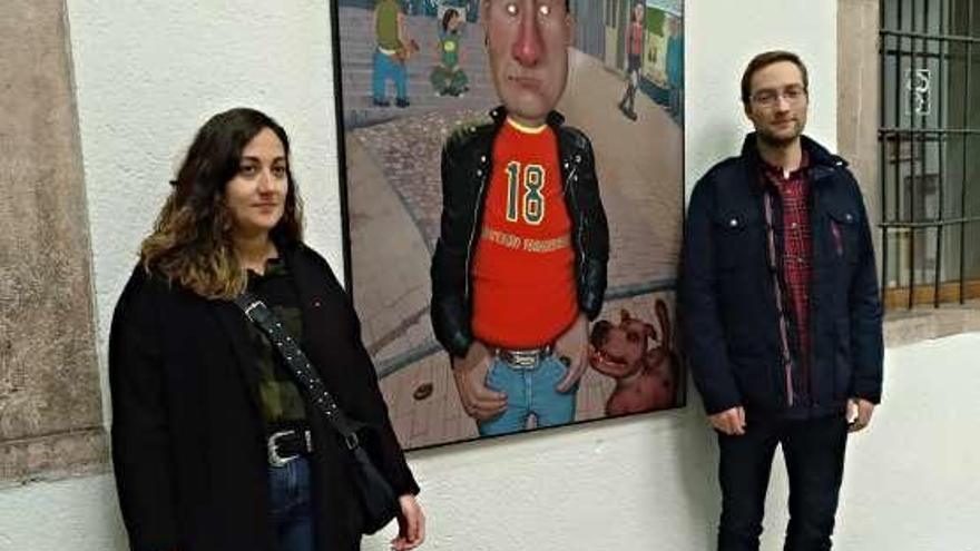 La teniente de alcalde de Grado, Elsa Suárez, y el secretario del Conseyu de la Mocedá, Daniel Carrillo, en la exposición de Carlos Cabrero.