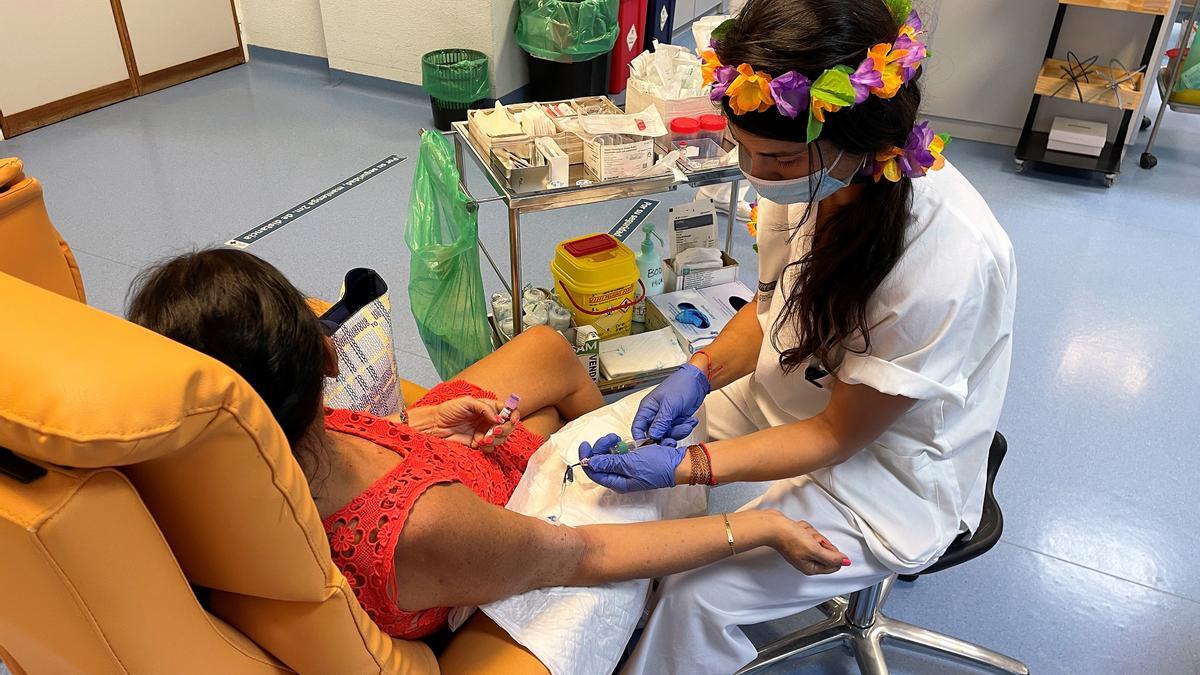 Una enfermera atiende a una paciente oncológica con su indumentaria para recibir agosto