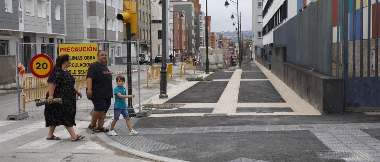 Una familia, cruzando ayer por la calle Calderón de la Barca, con la reforma de la vía paralizada. | Ángel González