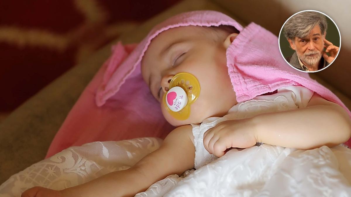 Un bebé duerme en un sofá.