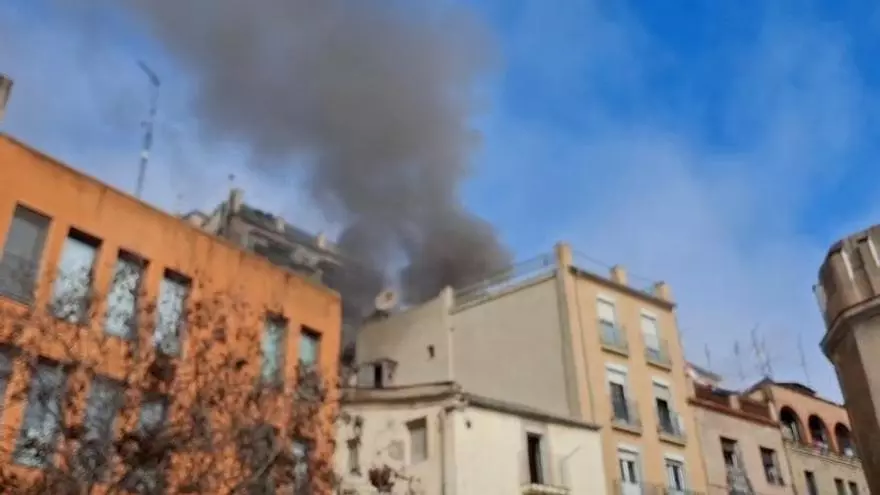Fum sortint d'una de les terrasses de l'edifici afectat al carrer Santa Llúcia
