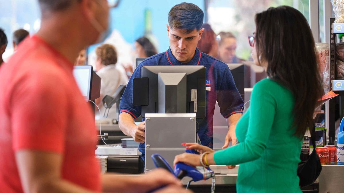 Un cajero pasa la compra en un supermercado.