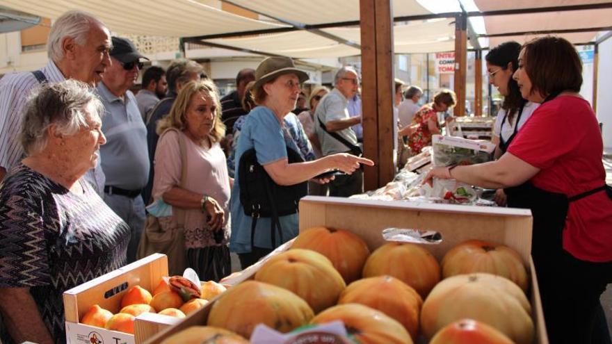 Un grupo de personas se interesa por el producto estrella de El Perelló en la ya consolidada feria del tomate. | LEVANTE-EMV