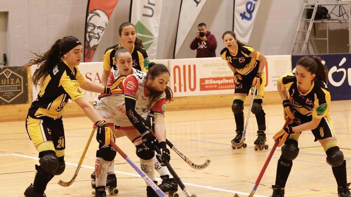Marta Piquero, con la bola, y Sara Roces, detrás rodeadas de rivales