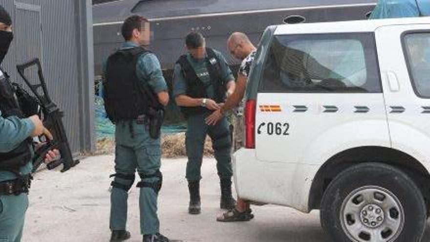 Agentes de la Guardia Civil en la nave industrial con uno de los detenidos.