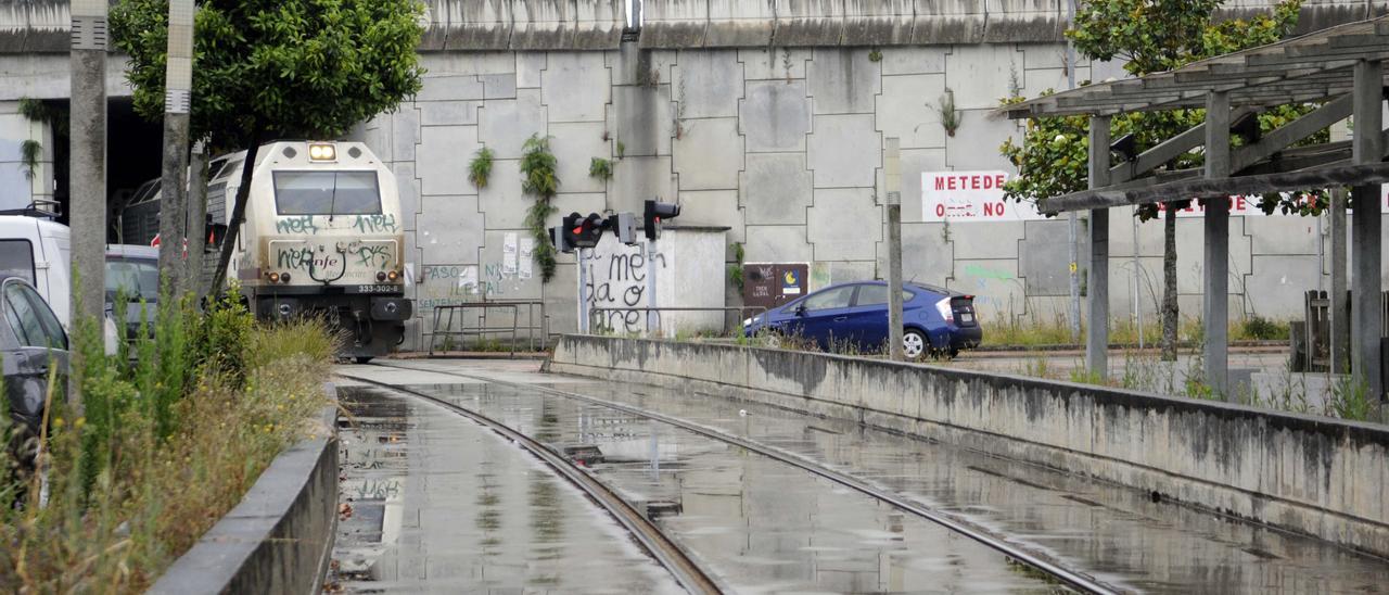 Un tren se dispone a pasar por los pasos a nivel ubicados en la plaza de Os Praceres.