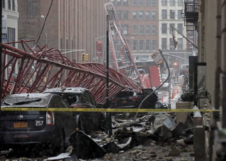 A construction crane is seen on top of cars along the street in downtown Manhattan, New York