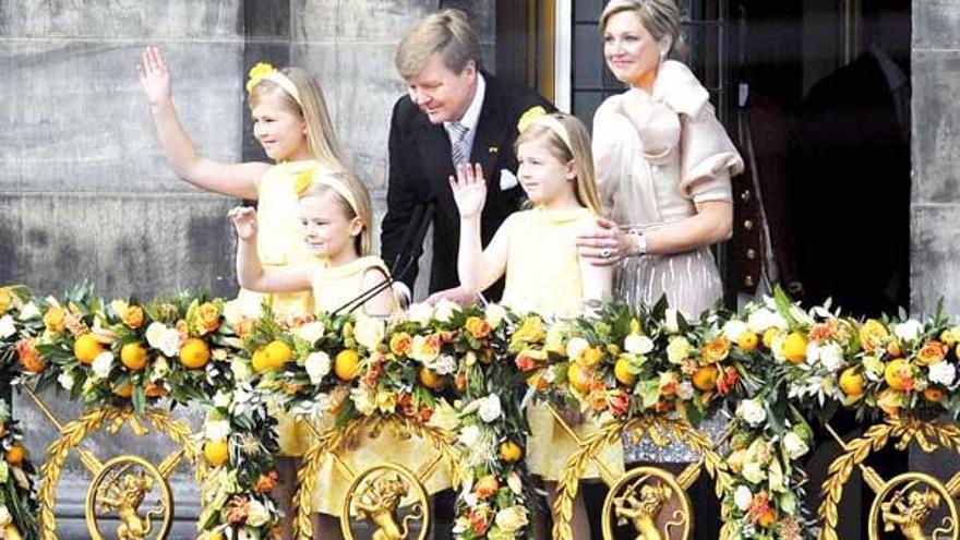 El nuevo rey Guillermo-Alejandro (izq), su esposa, la reina Máxima (dcha.), y sus hijas (de izq a dcha.) Catalina-Amalia, Ariane y Alexia saludan desde el balcón del Palacio Real en Ámsterdam  // Efe