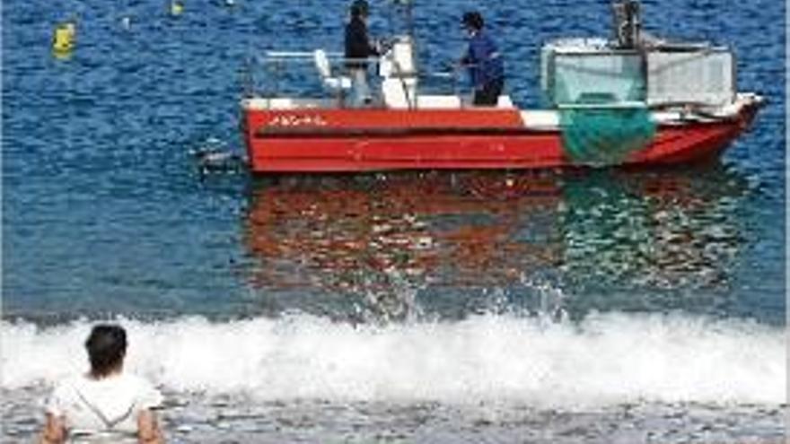 Una embarcació portant a terme la neteja a la costa gironina.