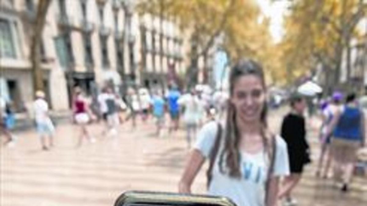 Dos jóvenes utilizan la aplicación Pokémon Go en la Rambla.