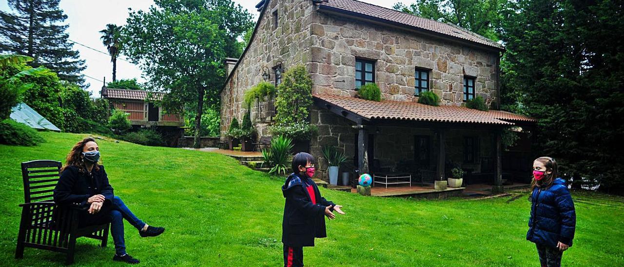 Maite Martínez, junto a sus hijos, en el jardín de la casa rural de la que es propietaria