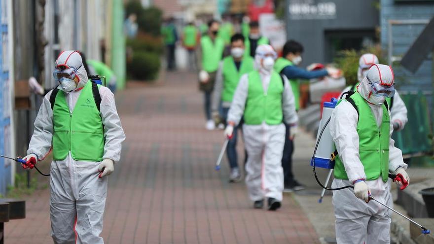 Trabajadores desinfectan una calle en Daegu (Corea del Sur).