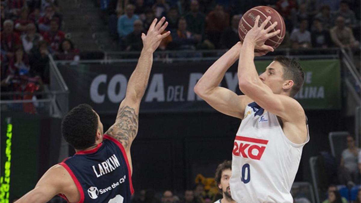 Jaycee Carroll trata de anotar por encima de Larkin