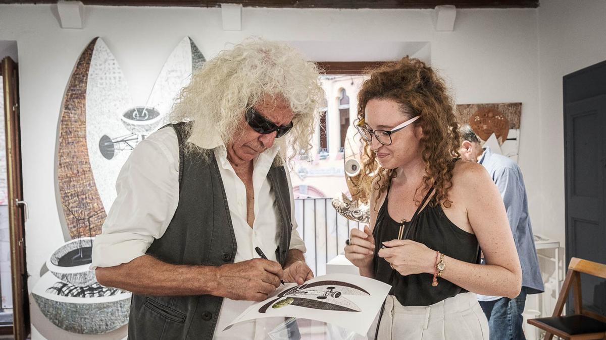 Antoni Federico signant una reproducció d'una de les seves obres el dia de la inauguració a la sala Can Viola.