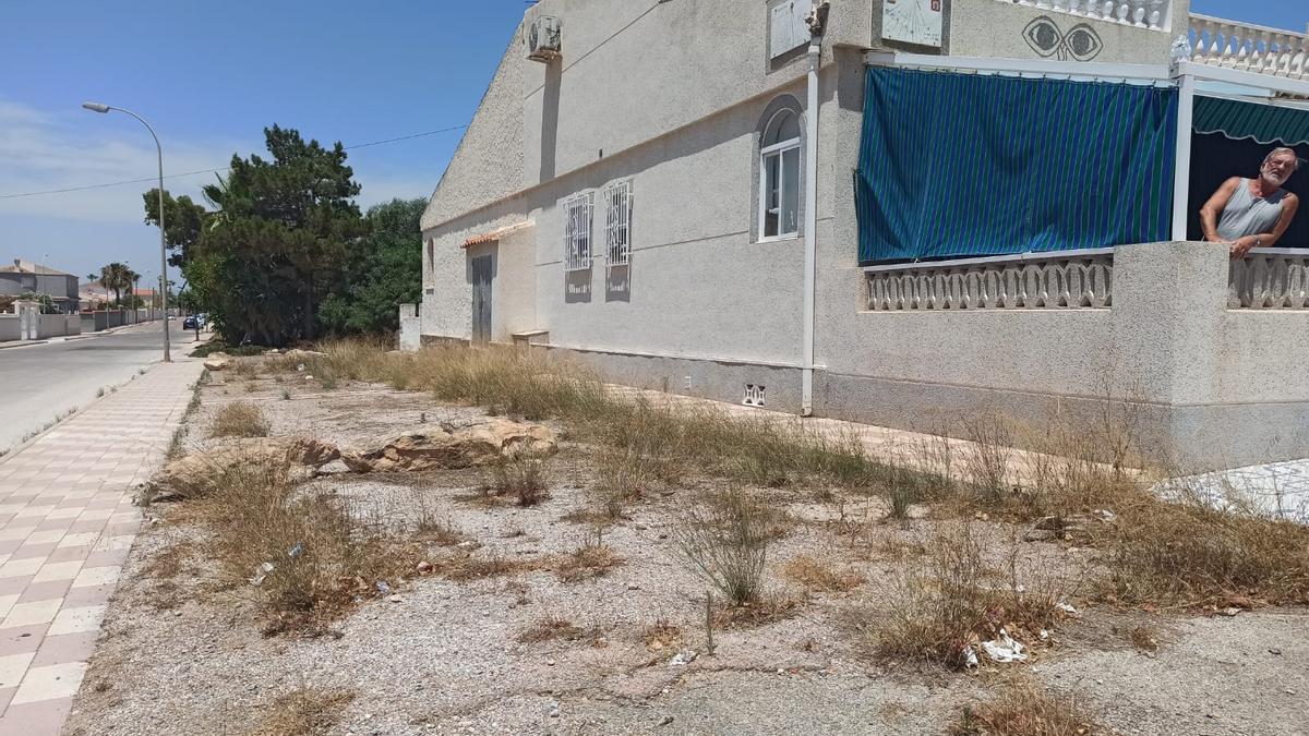 Manuel Pagola, a la derecha, en la vivienda y a la izquierda el terreno junto a la avenida del que nadie se hace cargo, en una situación que sufren cientos de viviendas de la zona