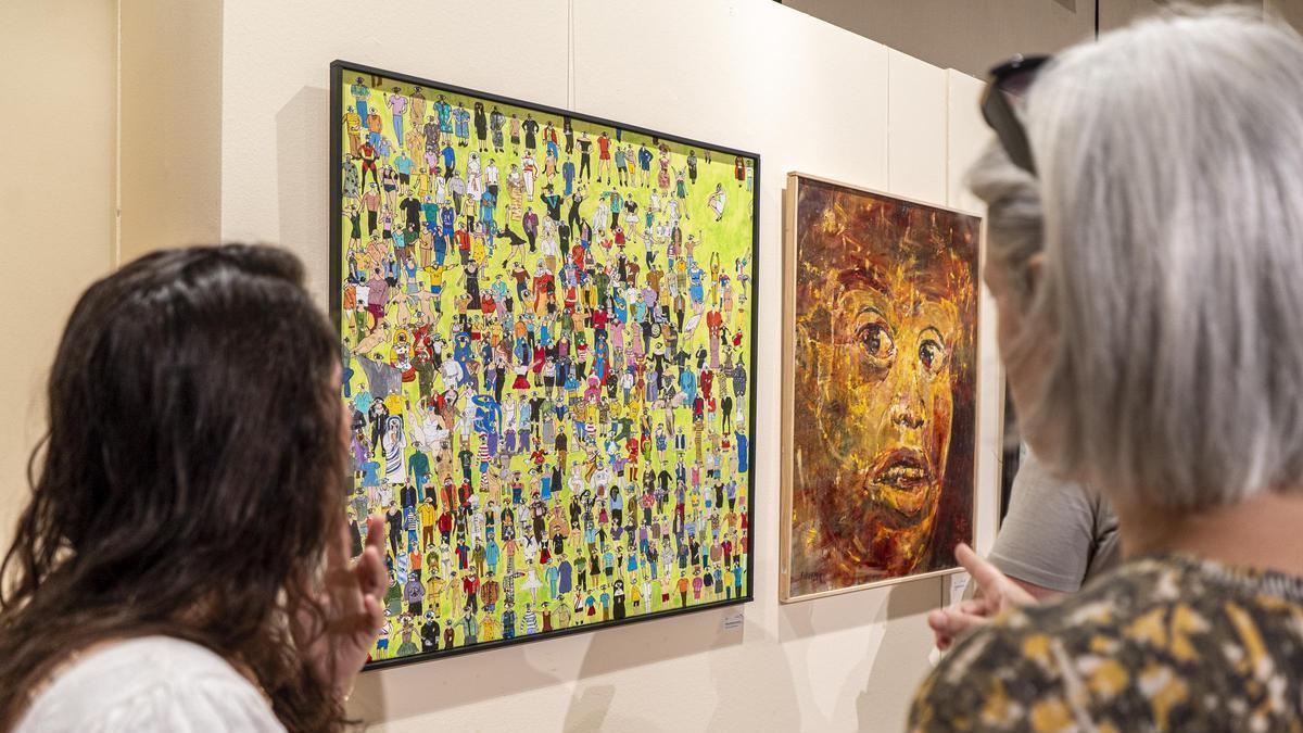 Dues dones contemplen obres de l’anterior concurs d’artistes manresans