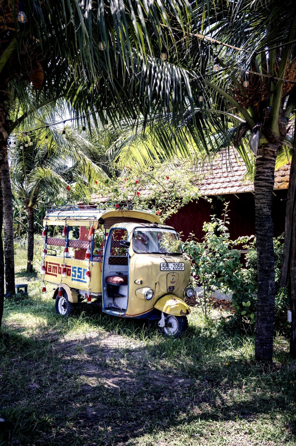 Un antiguo tuktuk en el jardín de un restaurante en Hoi An