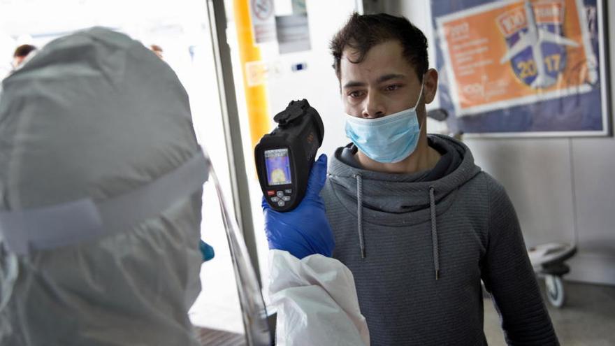 Un sanitario toma la temperatura a un hombre en Rumanía.