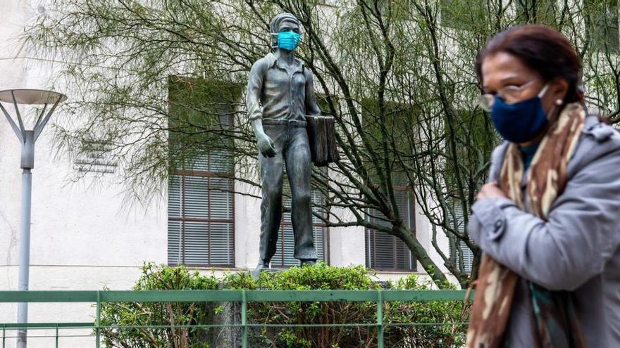 Una mujer pasa frente a una estatua con mascarilla en Montevideo, acción promovida por el Gobierno para fomentar el uso de mascarilla.