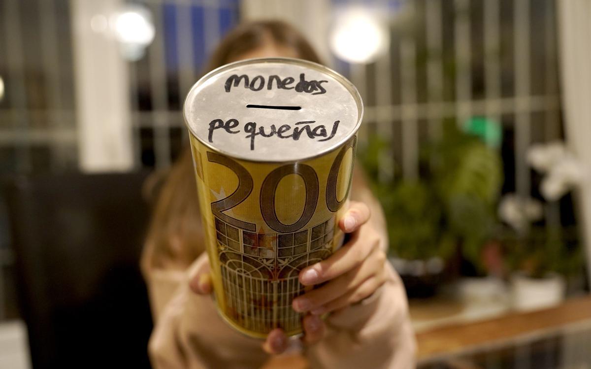 Una niña sostiene la hucha que le regaló su madre para ahorrar.