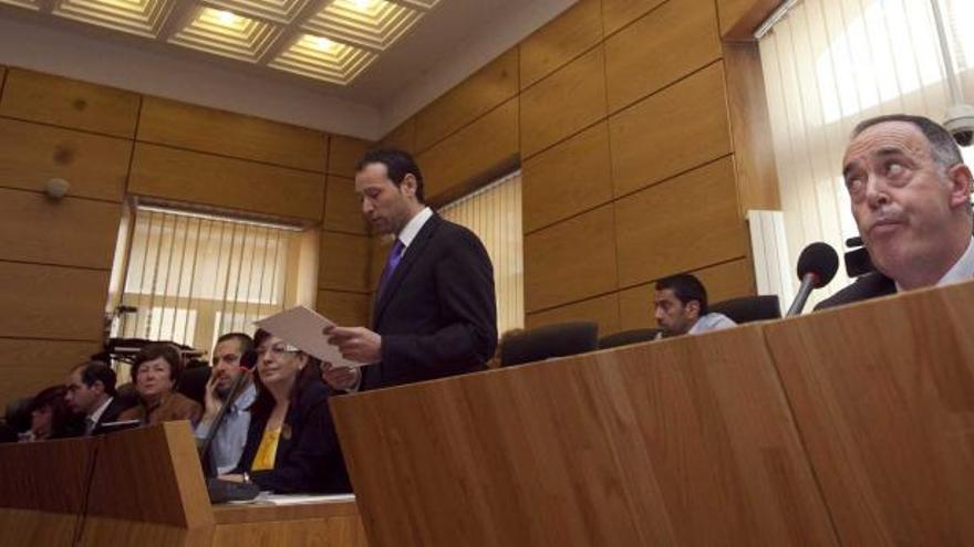 Guillermo Martínez, de pie, lee su discurso, con Eduardo Martínez Llosa en primer término.