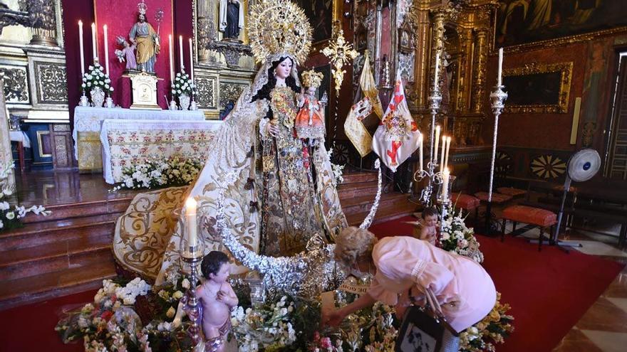 Una mujer deja flores a la Virgen del Carmen de San Cayetano.