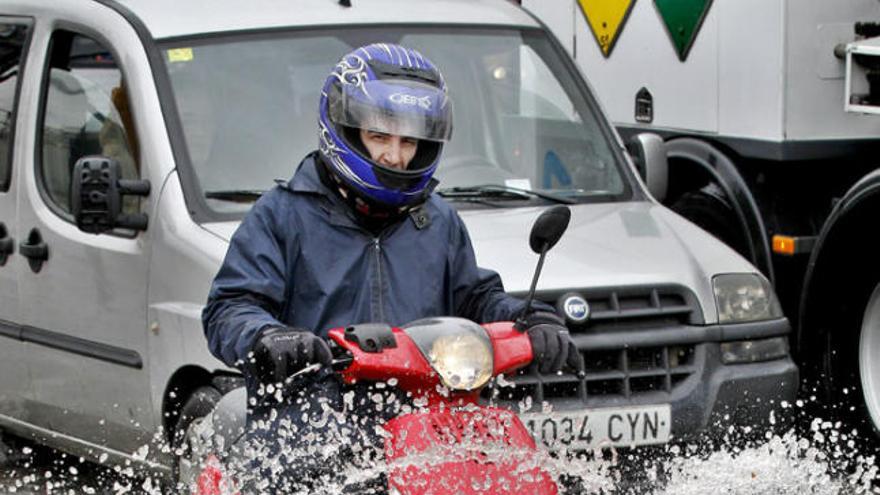 Un motorista, ahir, intentant conduir per Barcelona.