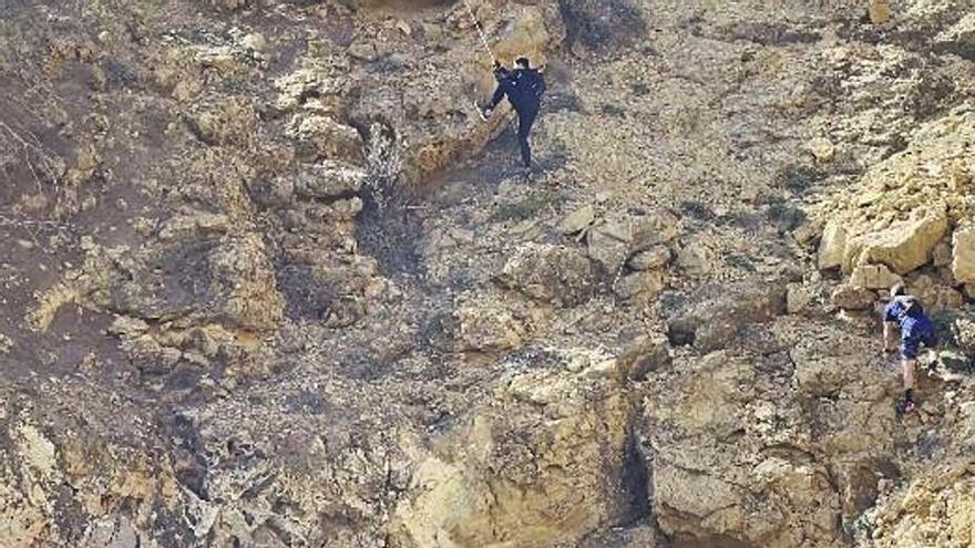 Para llegar a la platja de ses Ovelles, en la costa de es Cubells, deben superar una zona acantilada con una cuerda.