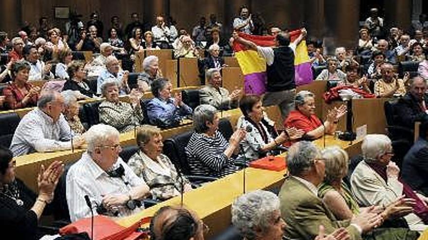 Los ex presos políticos del franquismo llegados a Madrid desde diversas comunidades autónomas para una jornada de homenajes extienden una bandera republicana durante la recepción que les ofreció hoy el presidente del Congreso de los Diputados, José Bono.