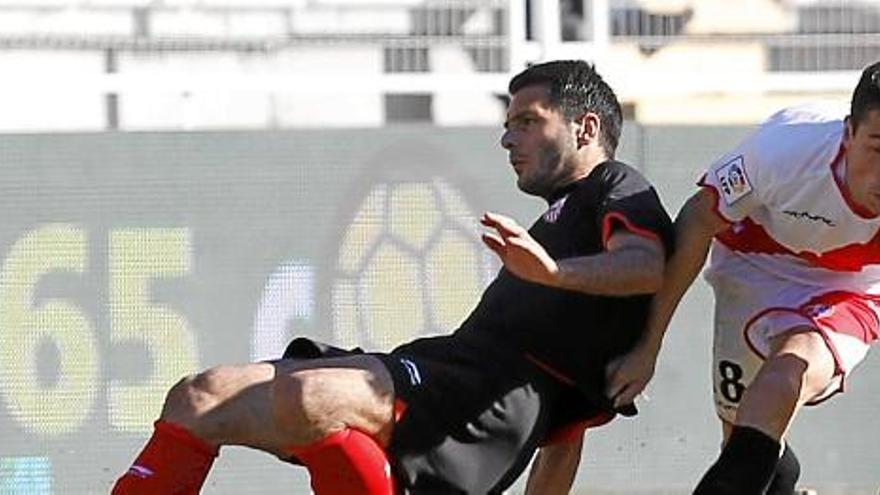 Javi Fuego pelea un balón con el defensa del Sevilla Spahic.