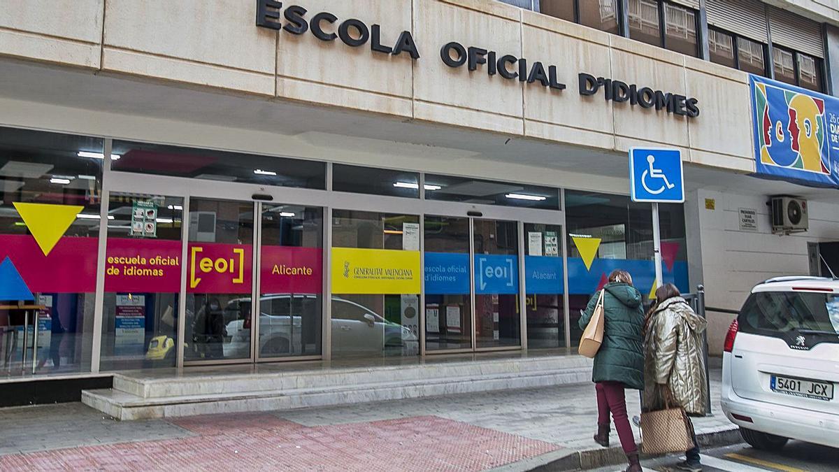 Alumnas accediendo ayer a la Escuela de Idiomas de Alicante, en cuya aulas no se quitan la ropa de abrigo y añaden mantas.