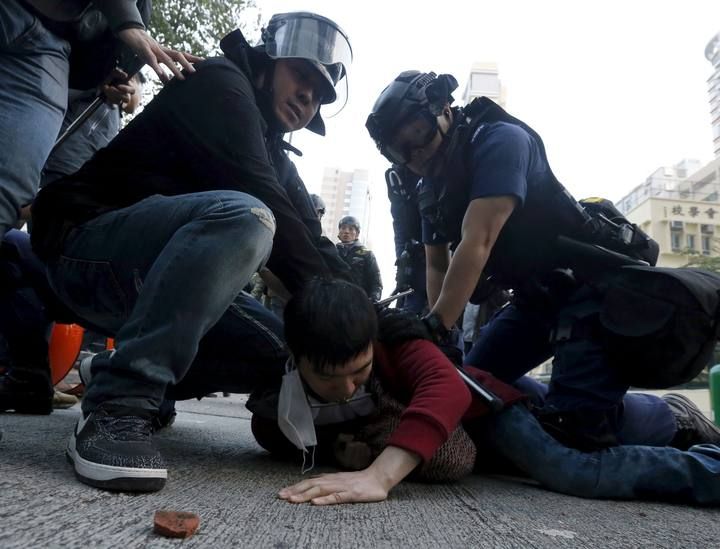 A protester is arrested by riot police at Mongkok district in Hong Kong