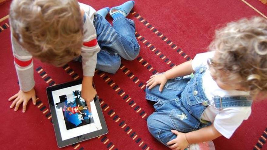 Dos niños juegan con un iPad // A.Pinacho
