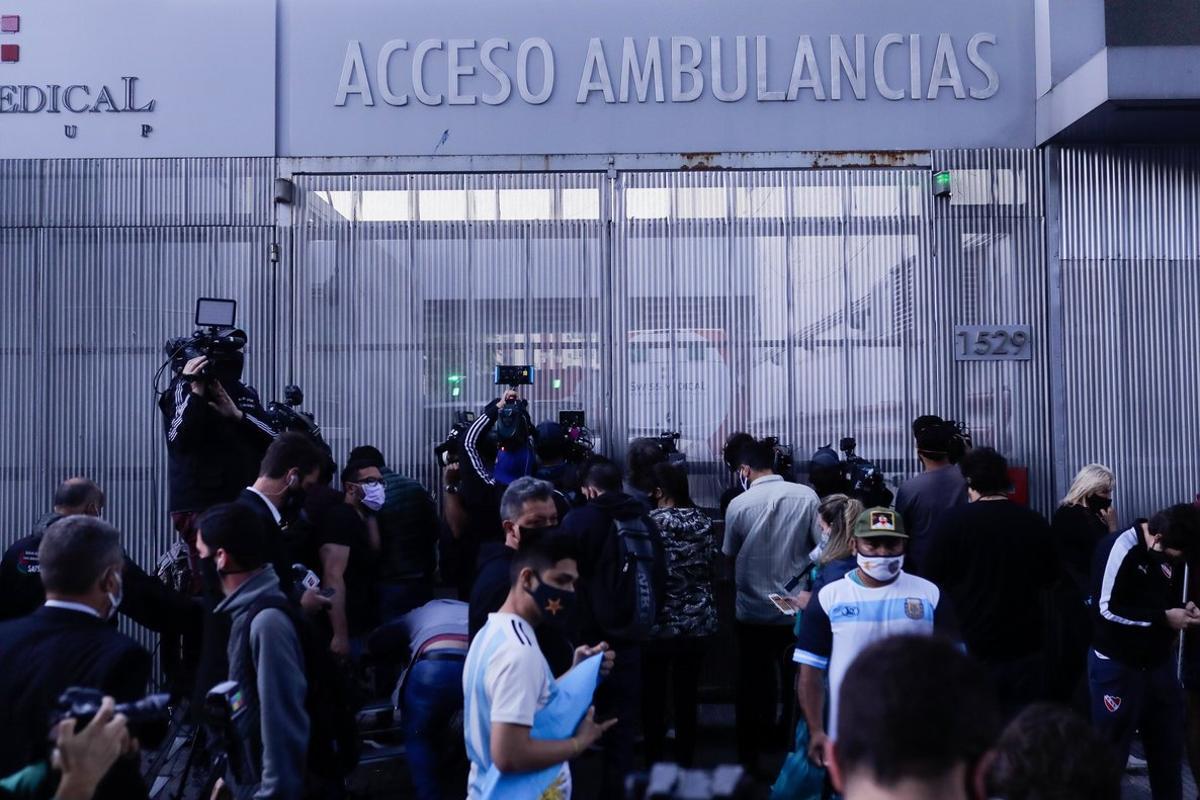 AME5658. OLIVOS (ARGENTINA), 03/11/2020.- Fanáticos del exfutbolista y entrenador argentino Diego Armando Maradona y miembros de la prensa permanecen a la espera de noticias afuera de la clínica donde llegó hoy para ser operado, en Olivos, en la provincia de Buenos Aires (Argentina). Maradona fue trasladado de una clínica de la ciudad de La Plata a otra de Olivos (provincia de Buenos Aires), a donde llegó entre gritos de apoyo y muestras de cariño, para ser operado esta noche de un hematoma subdural. EFE/ Juan Ignacio Roncoroni