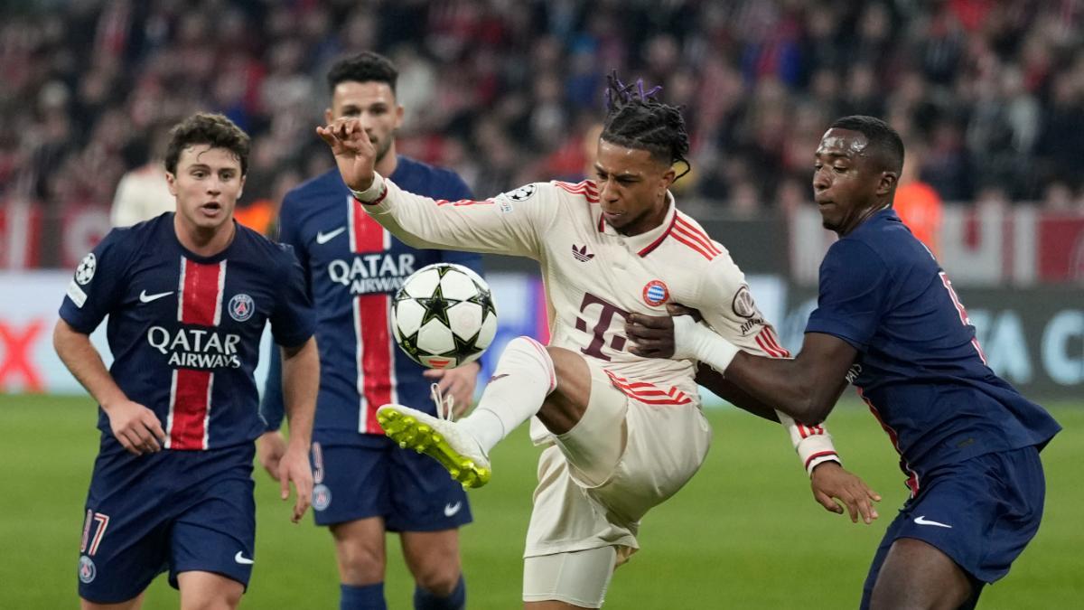 Michael Olise controla el balón entre tres jugadores del PSG