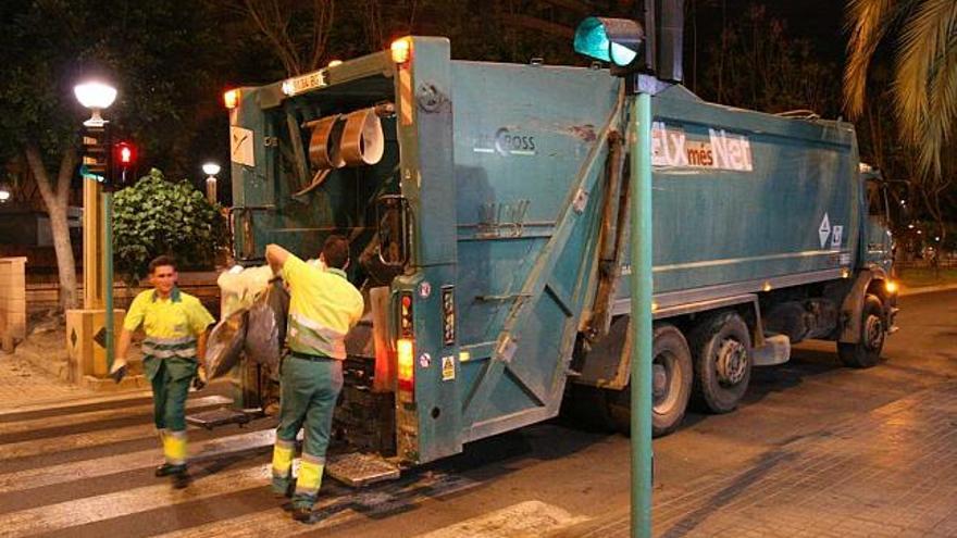 Dos operarios de la empresa Urbaser recogen las bolas de basura doméstica de la avenida de la Libertad