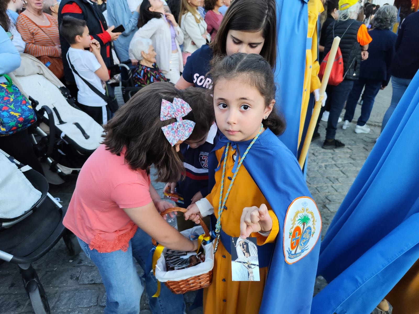 Palma del Río, La pequeña Aitana repartiendo estampas con las imágenes de los titulares de la Hermandad de los hortelanos