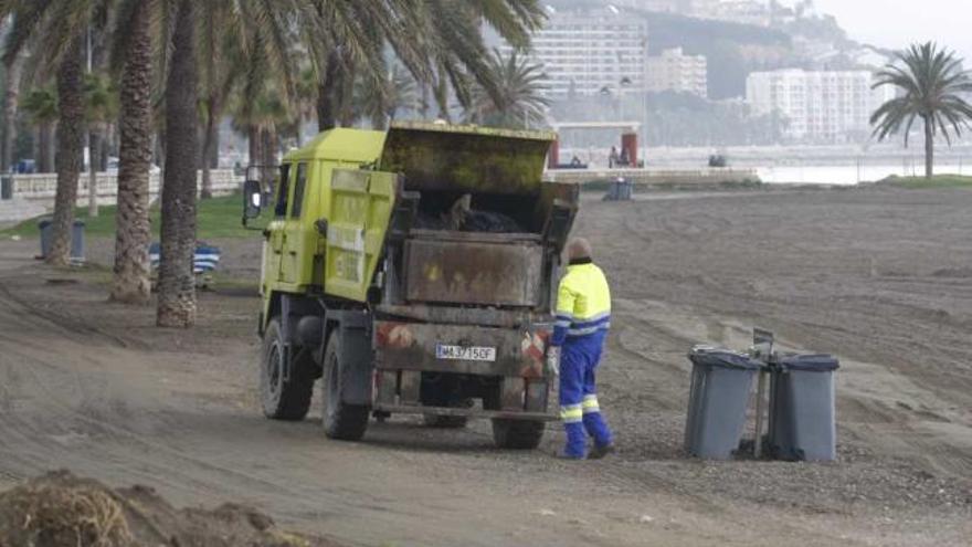 Operarios de Limasa realizando la limpieza de la playa de La Malagueta.