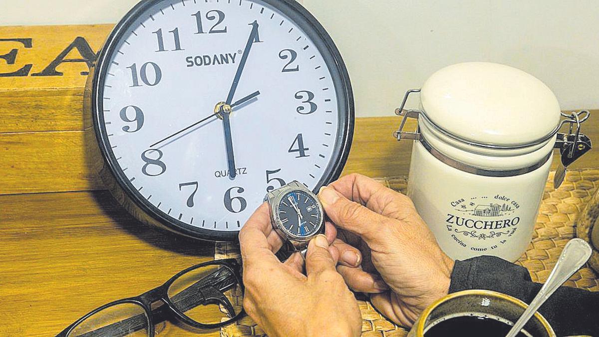 Un señor pone en hora su reloj.