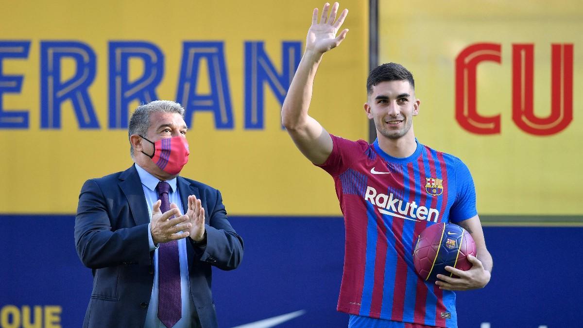 Ferran Torres junto a Joan Laporta en el césped del Camp Nou